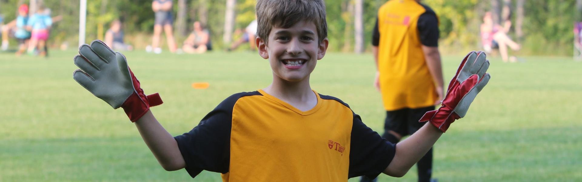 Youth soccer player smiling and waving hands