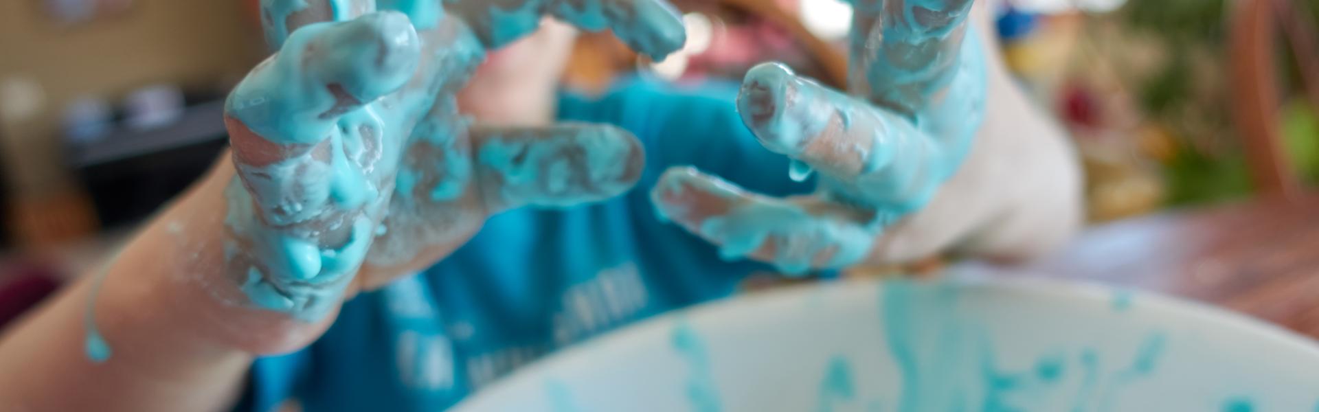 Young child with focus on slime covered hands