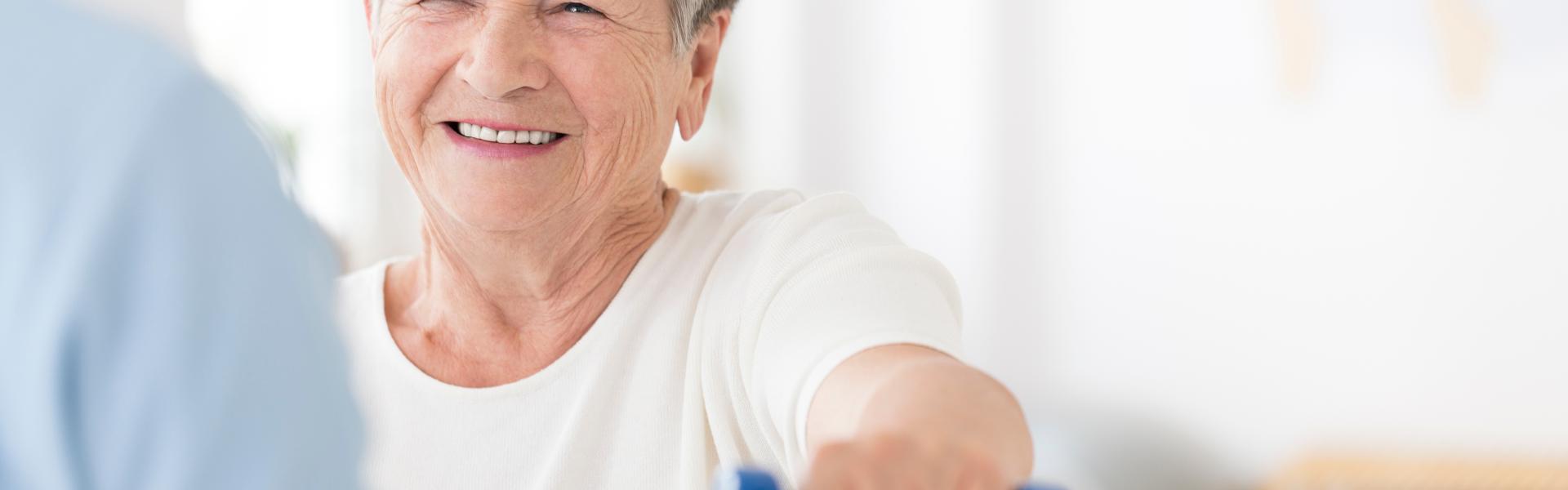 An older woman lifting a weight.