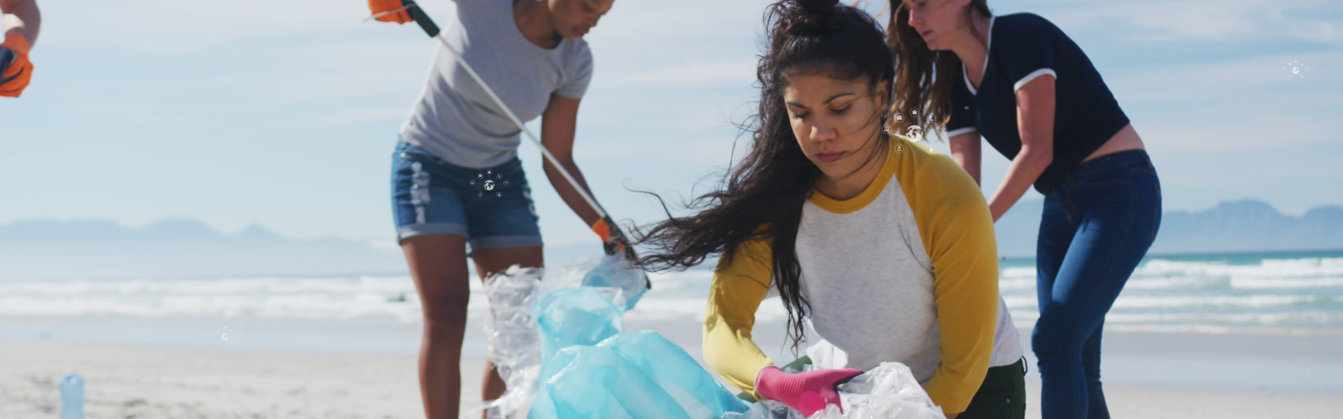 A group of volunteers cleaning-up garbage on a beach.