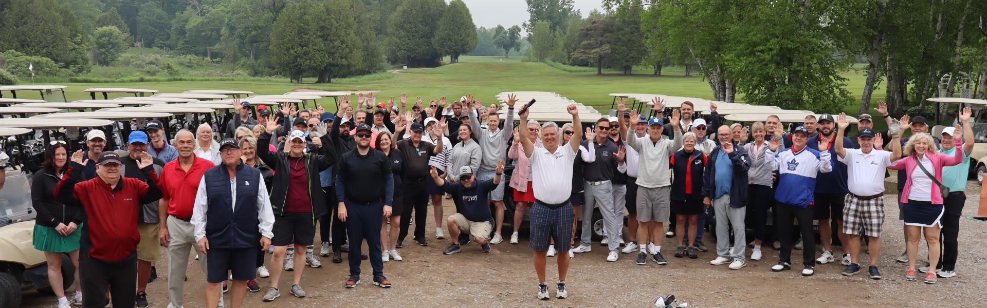 A large group of golfers posing for an overhead photo with the mayor.