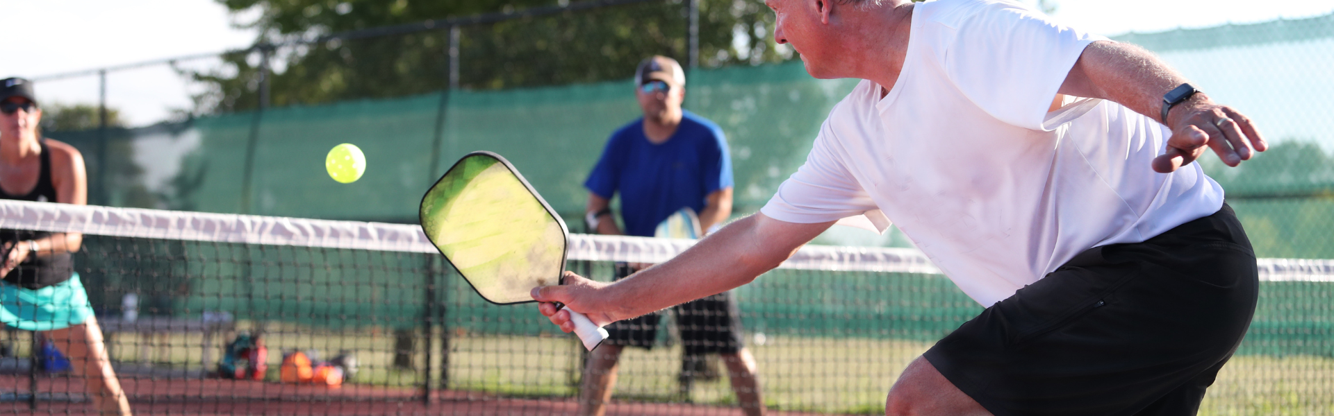 Three people playing pickleball.