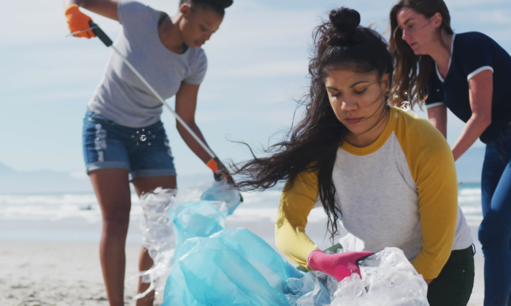 A group of volunteers cleaning-up garbage on a beach.