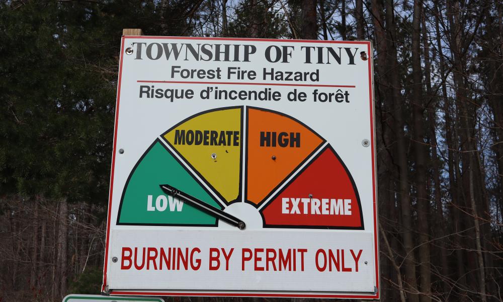 Township of Tiny's forest fire hazard sign that shows the fire rating as green-low of for levels. Burning by Permit Only