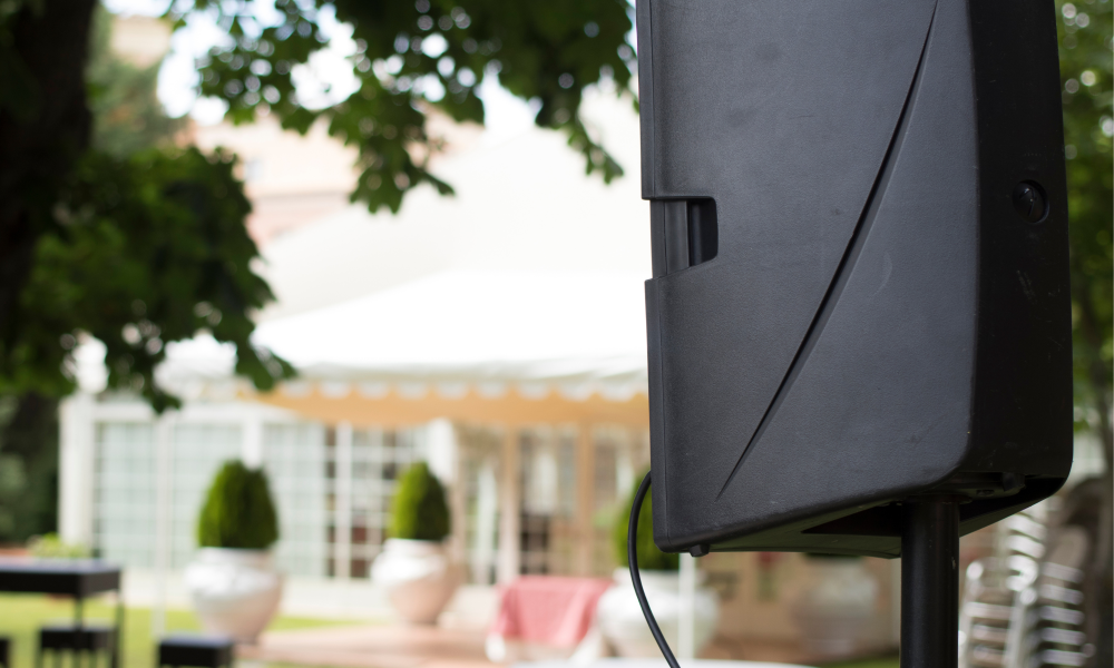 Large black speaker with outdoor furniture in the background