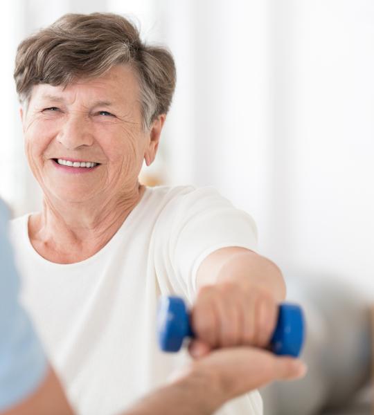 An older woman lifting a weight.