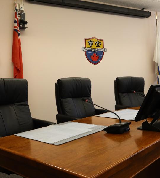 view from the left side of the council table with flags along the wall and the Tiny Crest