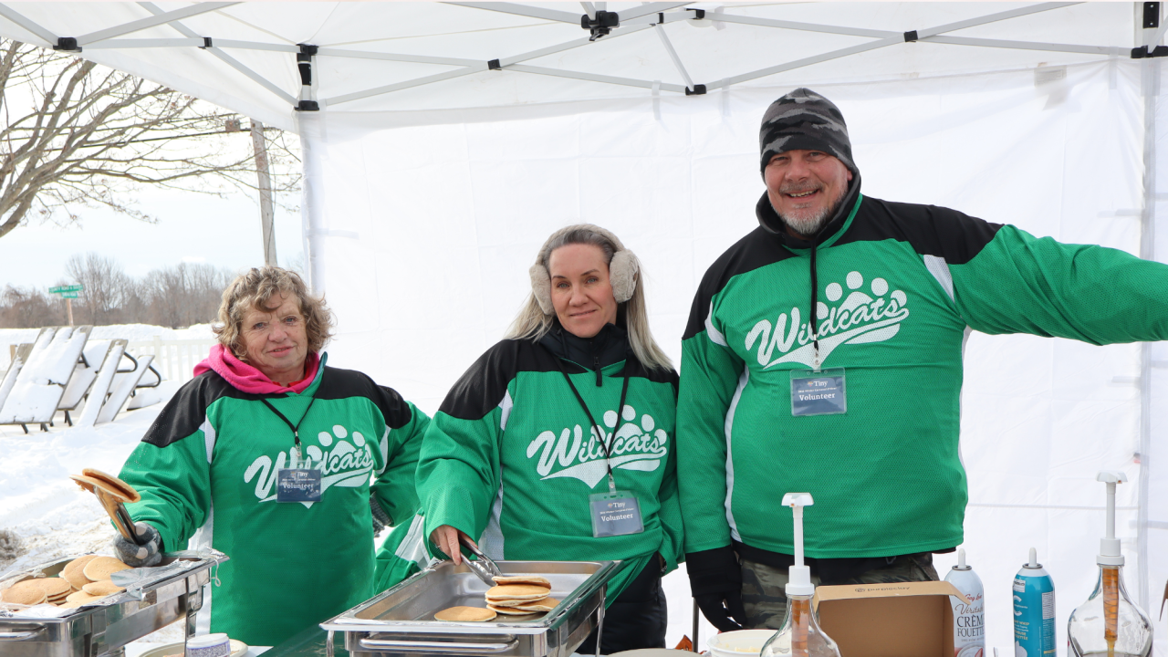 Volunteers at the condiments station handing out pancakes and maple syrup at the Winter Carnaval D'hiver