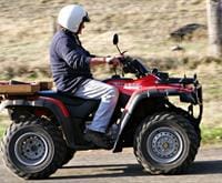 person wearing a helmet and driving an ATV