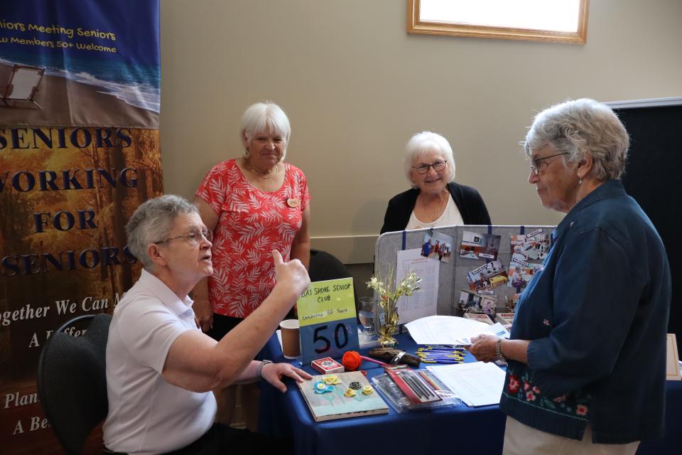 Bayshore Senior Club interacting with a participant at their booth at the Senior Symposium