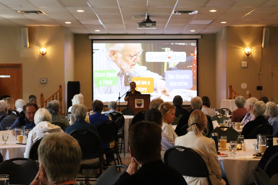 group of participants at the senior symposium sitting at tables and listening to a presentation