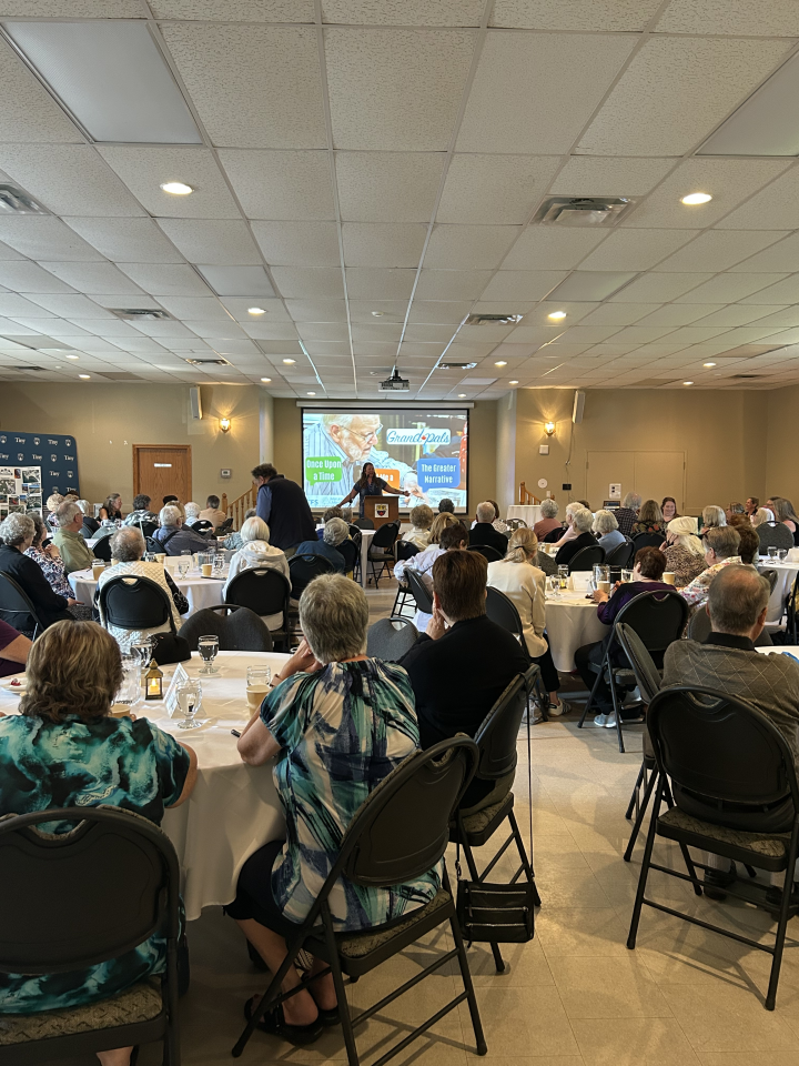 group of participants at the senior symposium sitting at tables and listening to a presentation