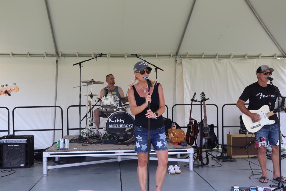 Kitty and the Boyz band performing with a focus on Kitty