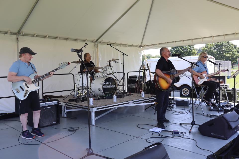 Bustin' Loose performing under a large white tent