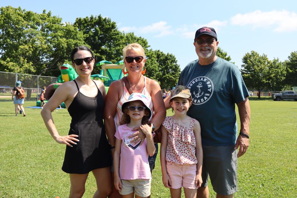 family enjoying the activities at the community bbq in the kid's zone