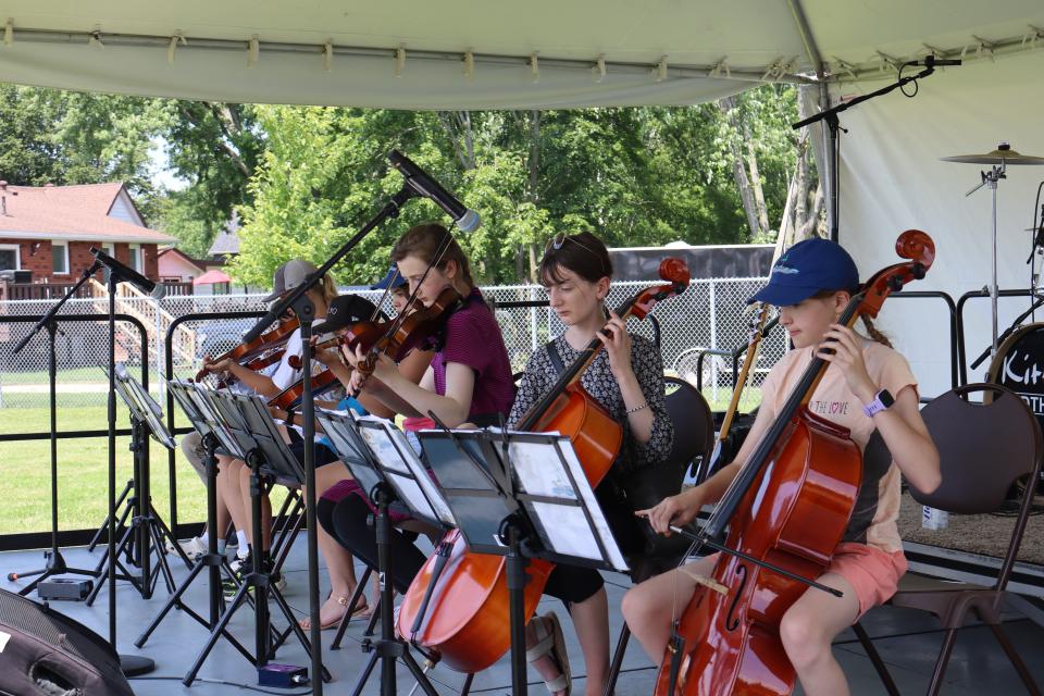 Sistema Huronia Music Academy performing at the community bbq on stage with various instruments