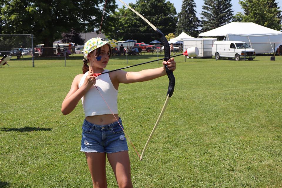 girl practicing archery at the community bbq