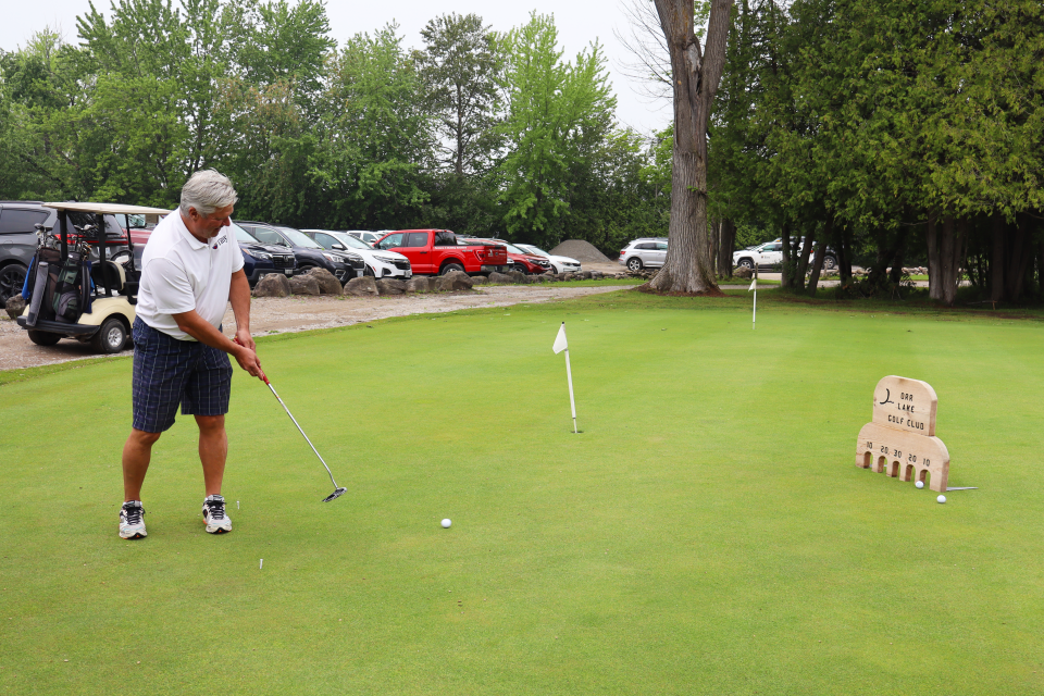 Mayor David Evans after hitting the golf ball at the putting challenge.