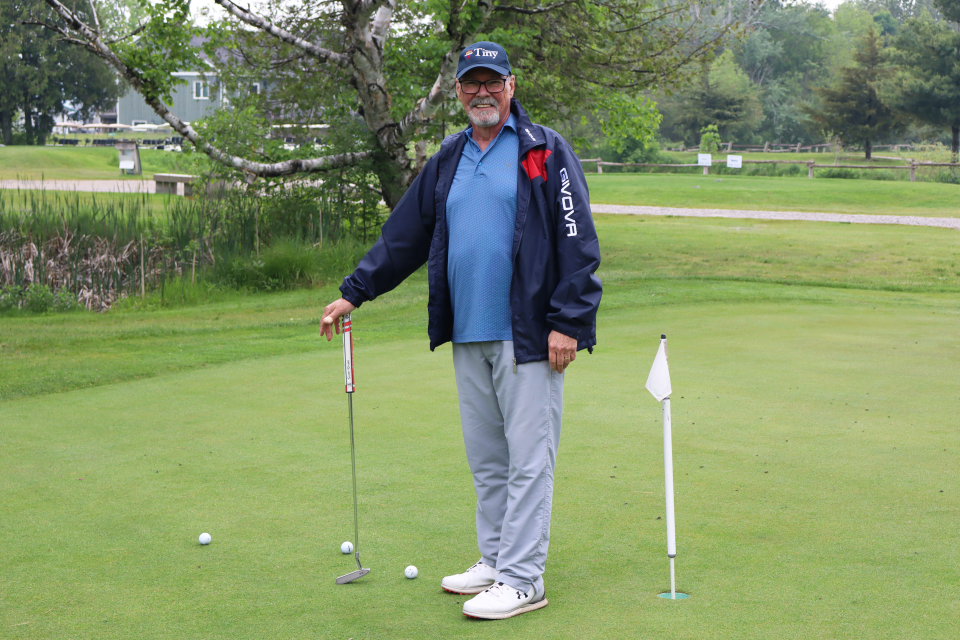 man posing in the putting challenge area of the course 