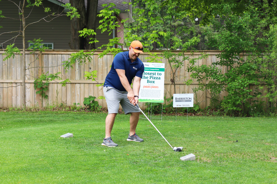 Councillor Steffen Walma lining up their swing in front of the Closest to the Pizza Box sponsored hole.