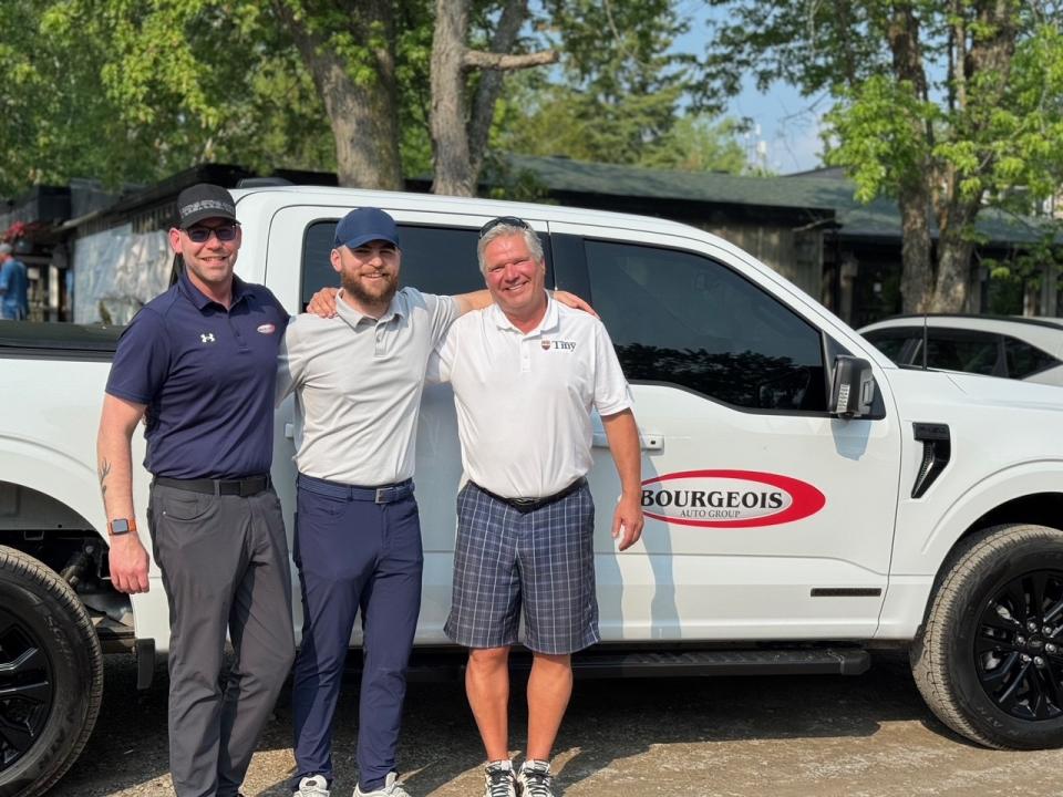 Hole-in-one winner celebratory photo. From left to right: Bourgeois staff, winner Silvio Zitoli, and Mayor David Evans.