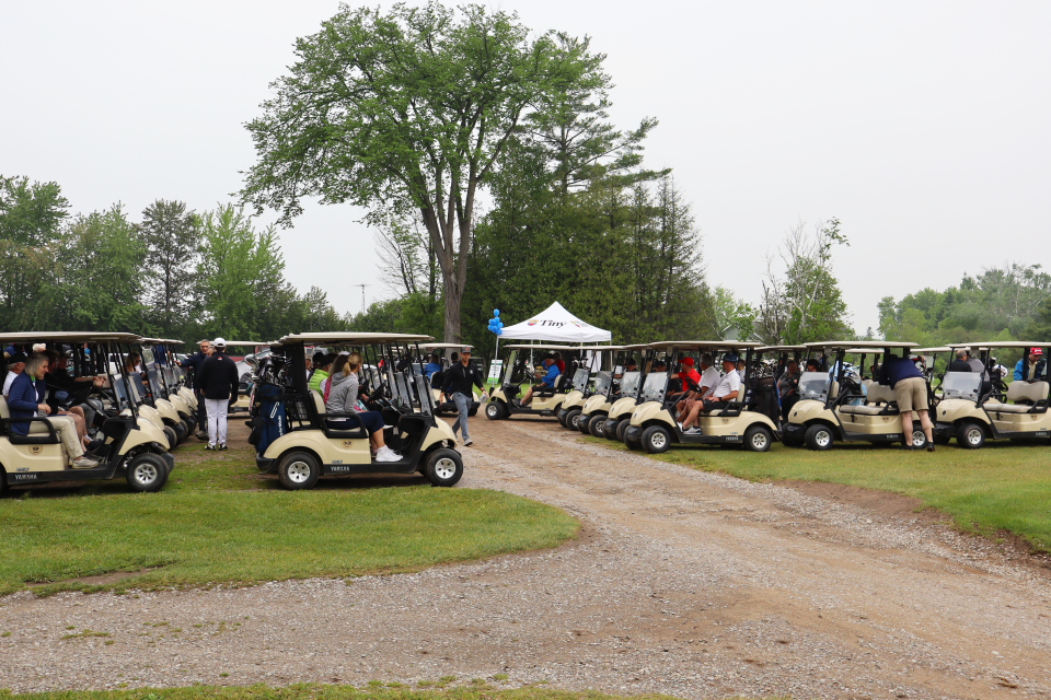 Rows of golf carts filled with participants right before heading out onto the course.