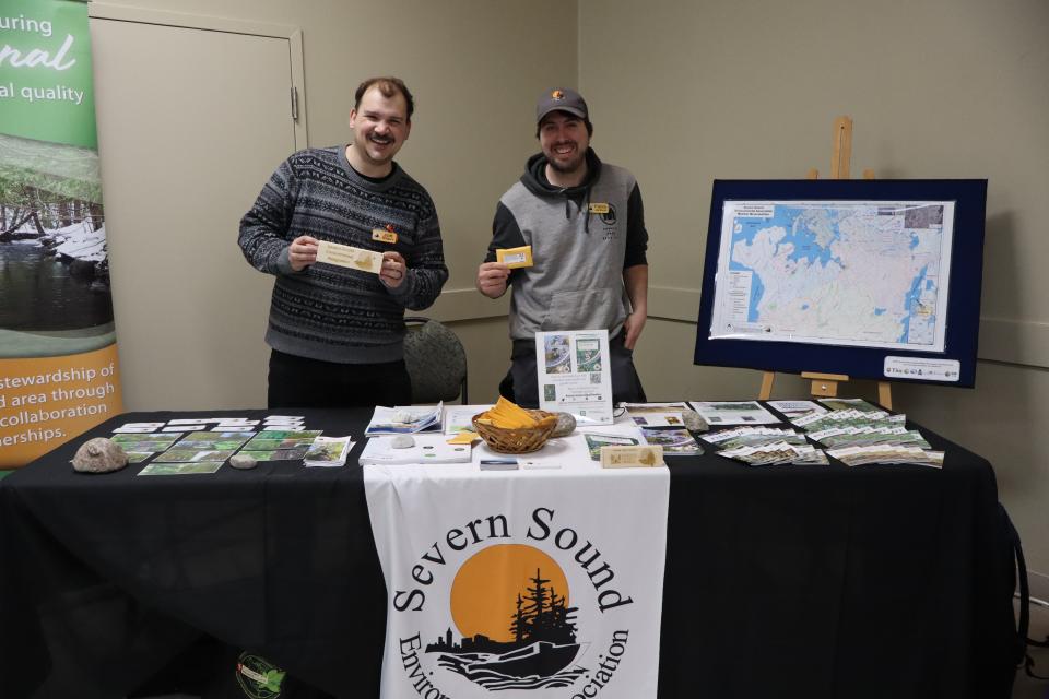 Severn Sound Environmental Association staff showing a brick from their new block tour and free seed packets for participants