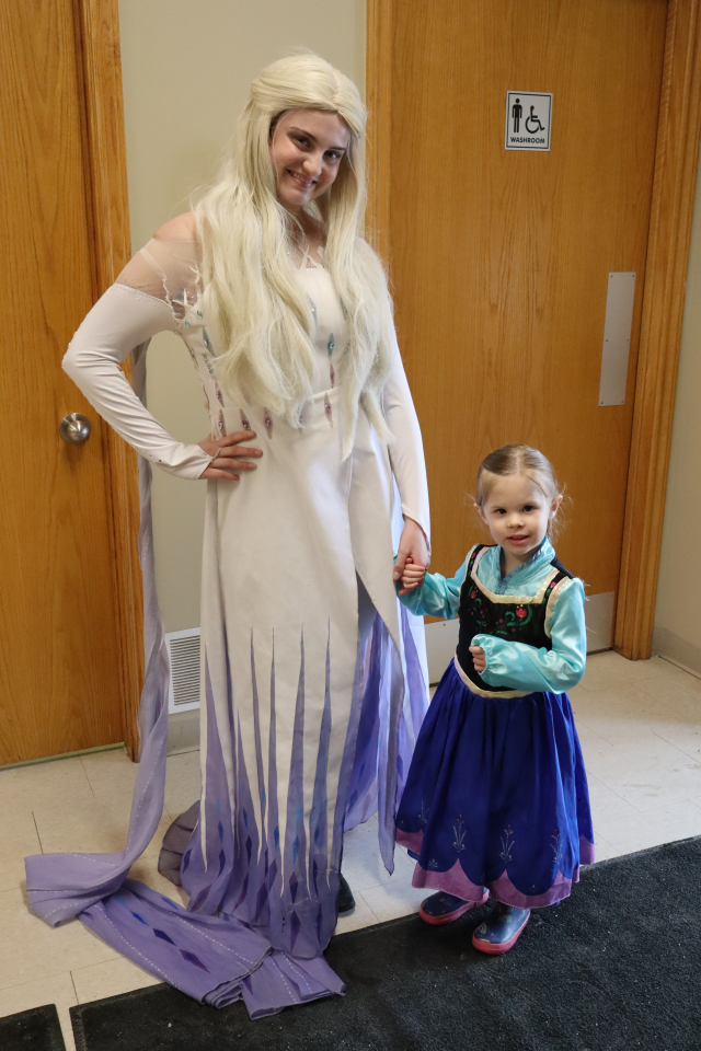 Elsa from Frozen posing with a young girl dressed as Ana from Frozen