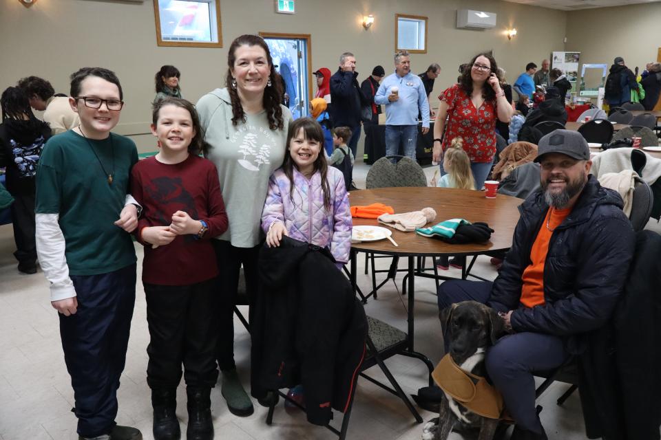 Young family with three kids just before sitting down to have a pancake lunch