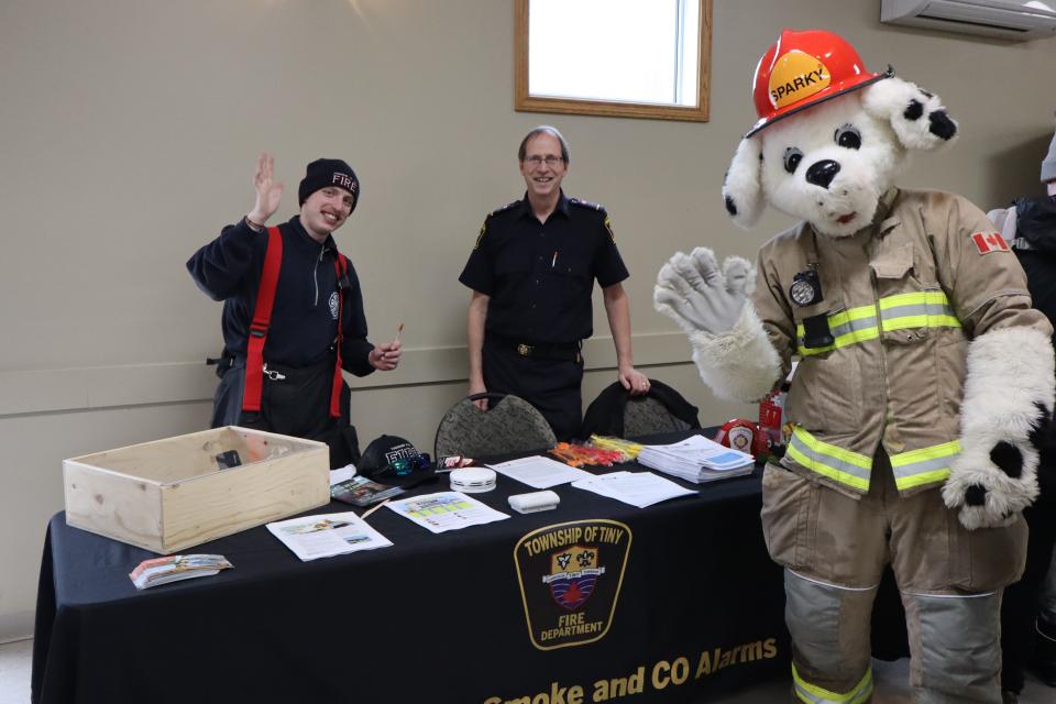 Members of Tiny Fire and Sparky the dog at their inside booth