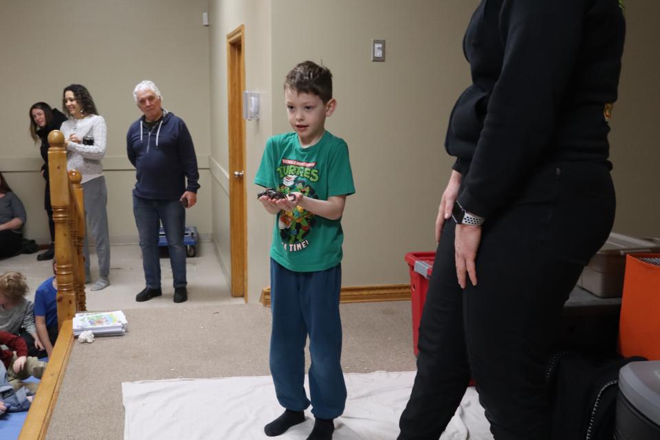 Child on stage holding a scorpion