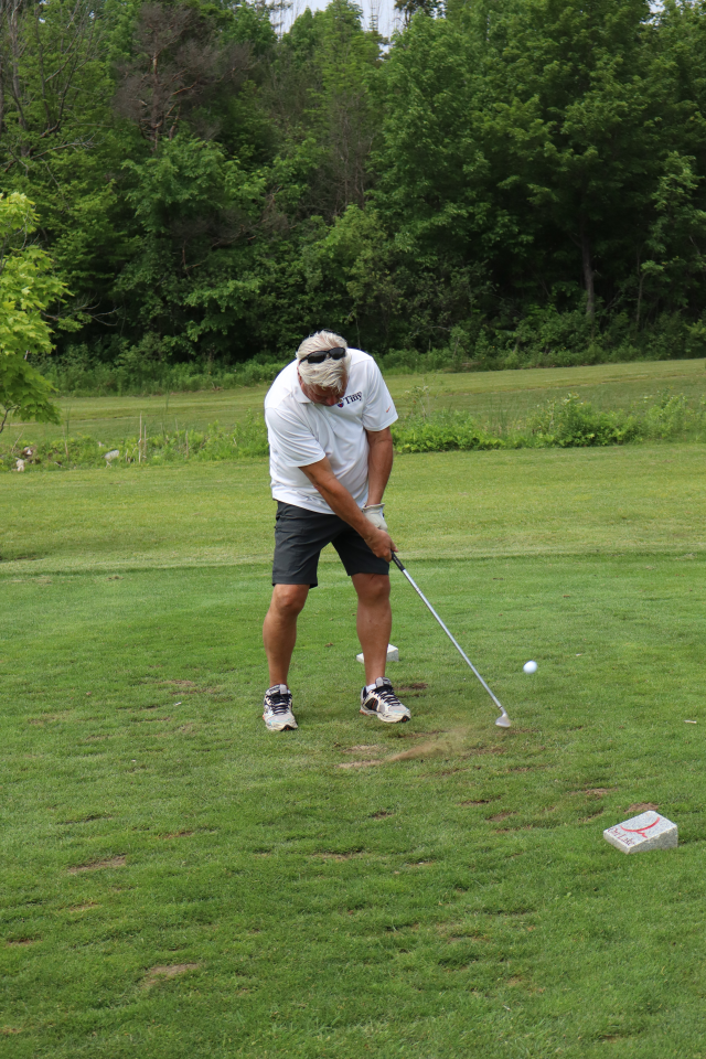 Mayor David Evans as his golf swing is all the way through and the ball begins to ascend off the ground