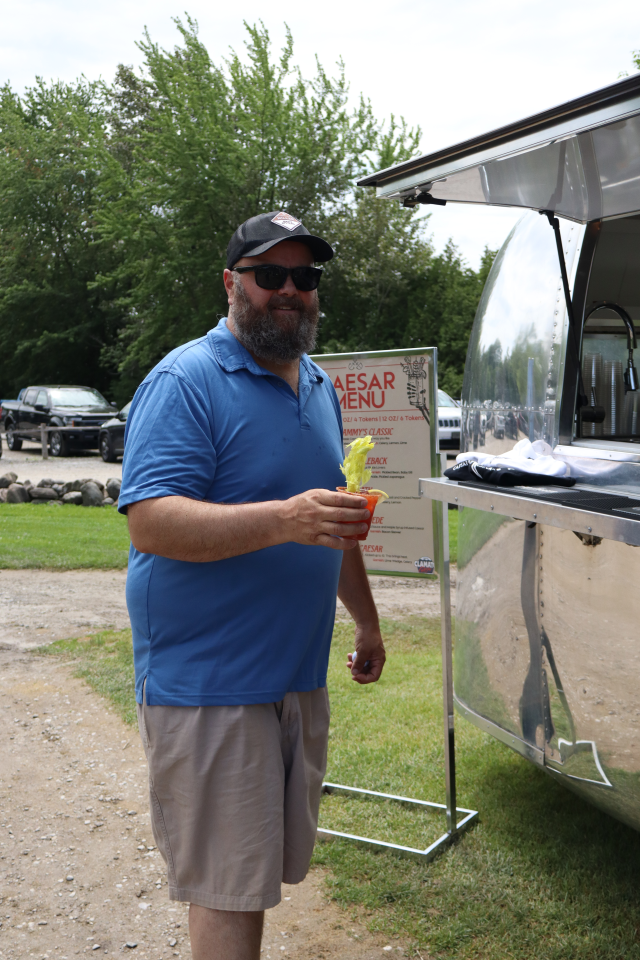 A man smiling and holding a Caesar Cocktail