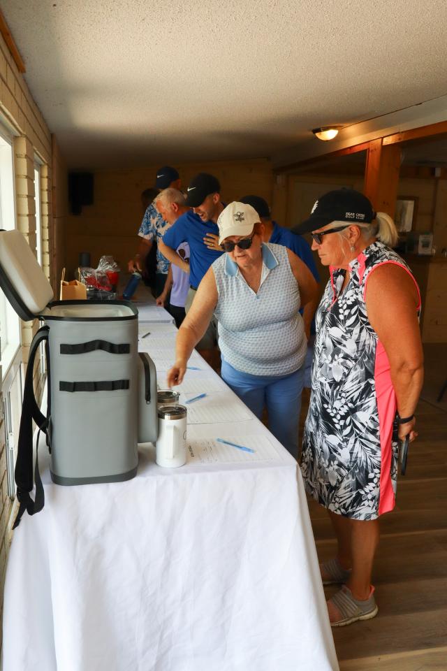 Golfers inside looking at the silent auction tables