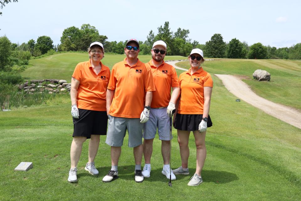 Golf foursome posing together and smiling