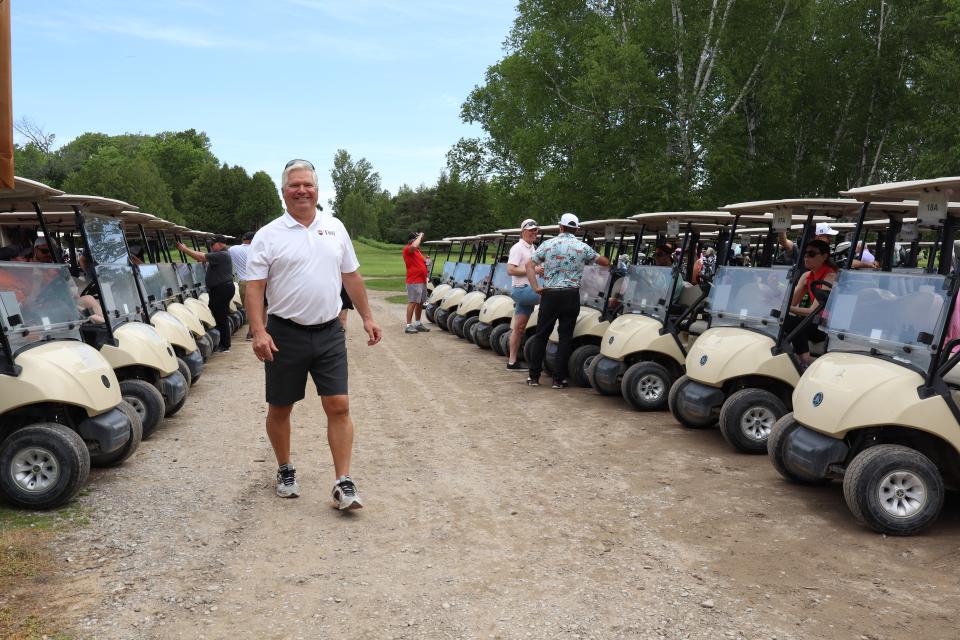 Mayor David Evans standing in front of golf carts