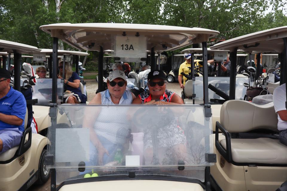 Two ladies sitting in a golf cart