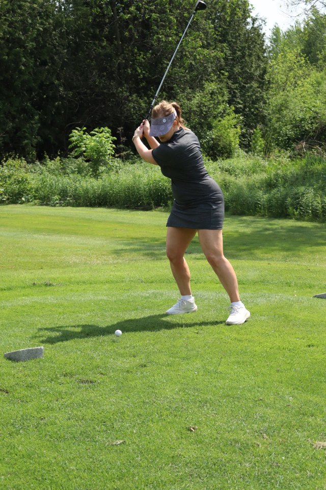 A woman lining up their golf swing