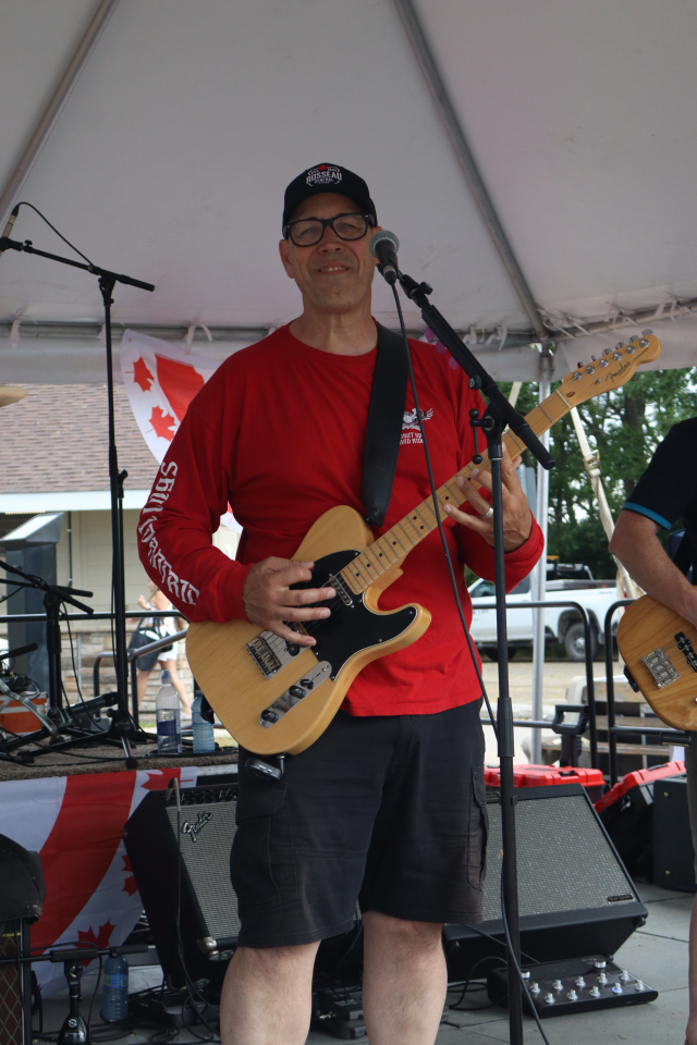 Guitarist from The Rick Robichaud Band performing on stage.