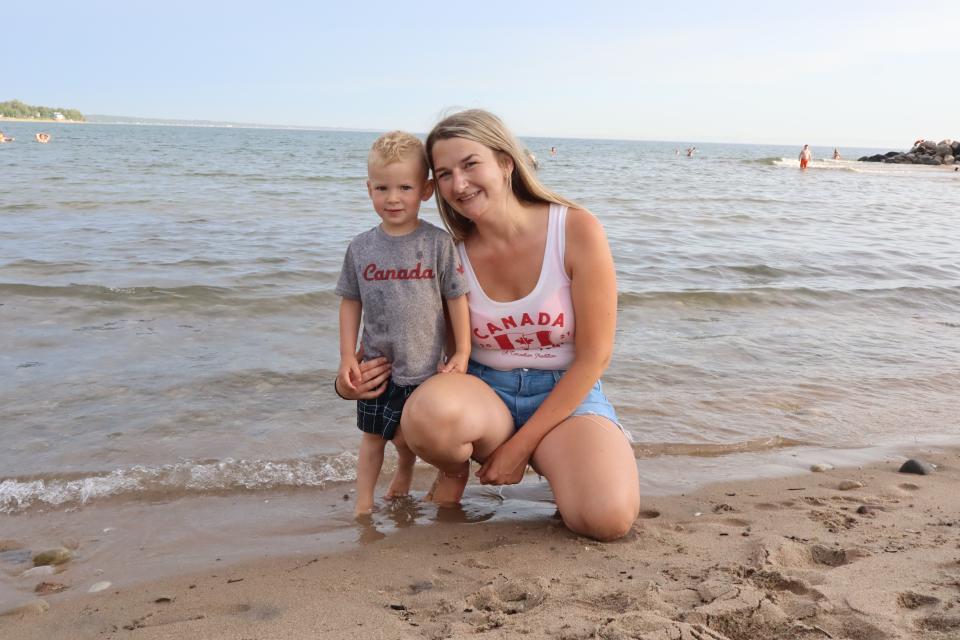 Mother and son posing at the water's edge wearing Canada Day clothing.