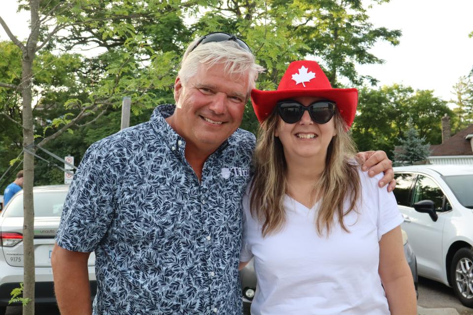 Mayor David Evans standing with a woman wearing a red hat with a white maple leaf.