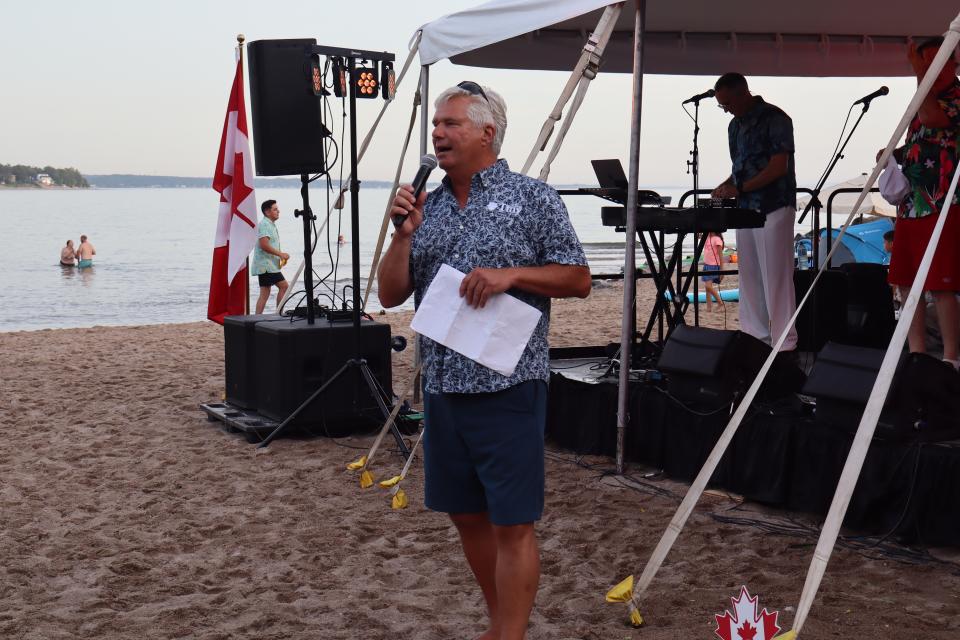 Mayor David Evans giving a speech in front of the stage.