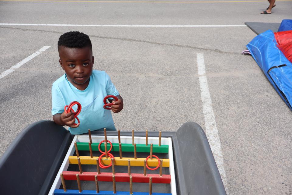 Child playing a carnival game with rings and multi-coloured pegs.