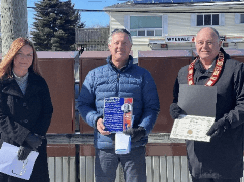 Three people posing with awards
