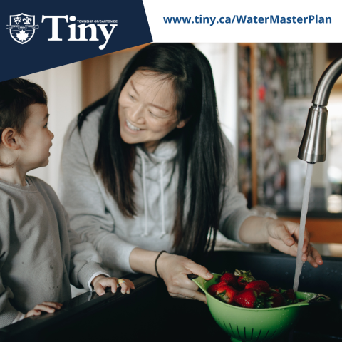 image of mother showing their child how to wash strawberries at the kitchen sink