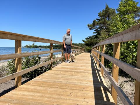 image of Mayor Evans and his dog walking on the Woodland Beach boardwalk