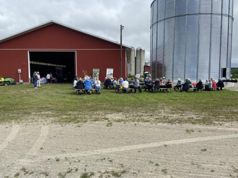 image of farm crawl guests at picnic benches in front of a farm