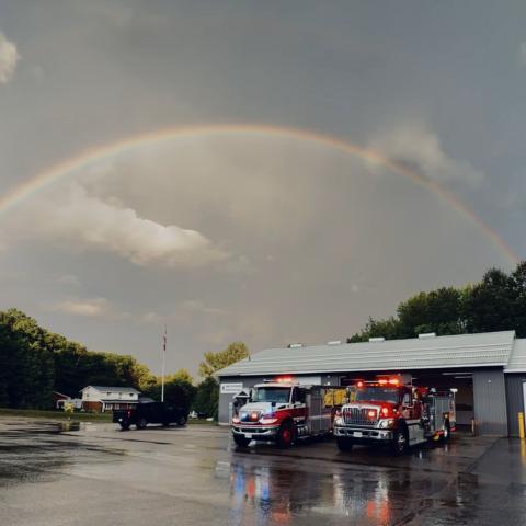 rainbow over station 3 fire department with trucks and their lights on out front