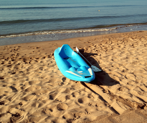 kayak and paddle left unattended on the beach