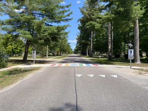 view of the colourful crosswalk in Wyevale near the public school showing new beacon light crossing safety feature on a sunny day with trees lining both sides of concession road 5
